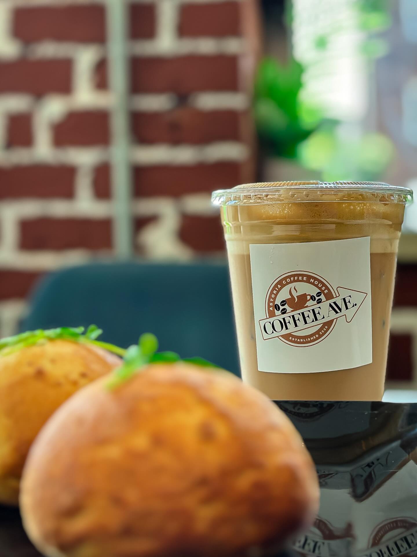 Iced latte with the Coffee Ave logo, pastries in front